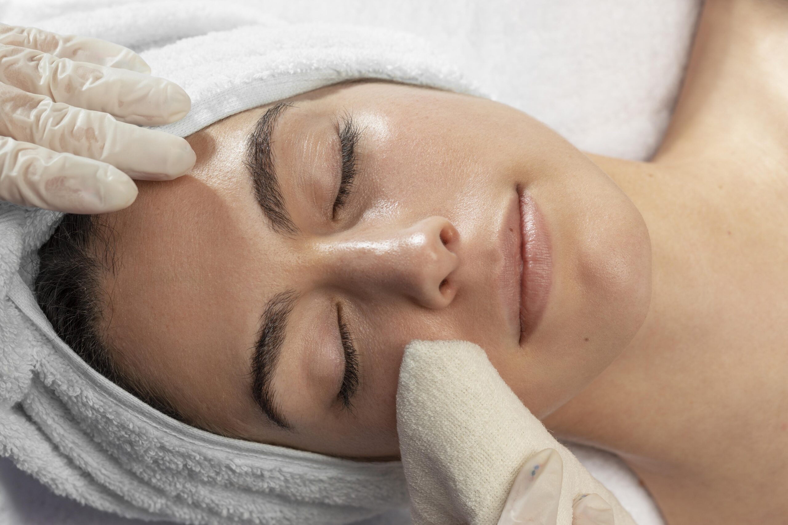 Illustrative image: Hands dispensing skincare onto a cotton pad
